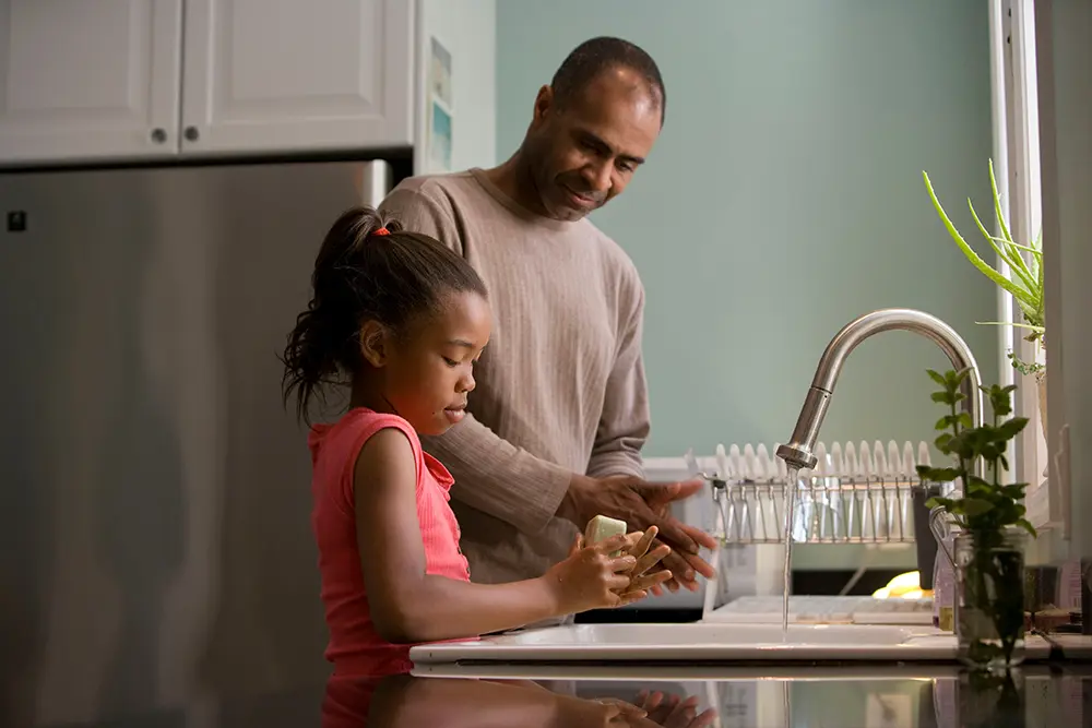 father and girl washing up