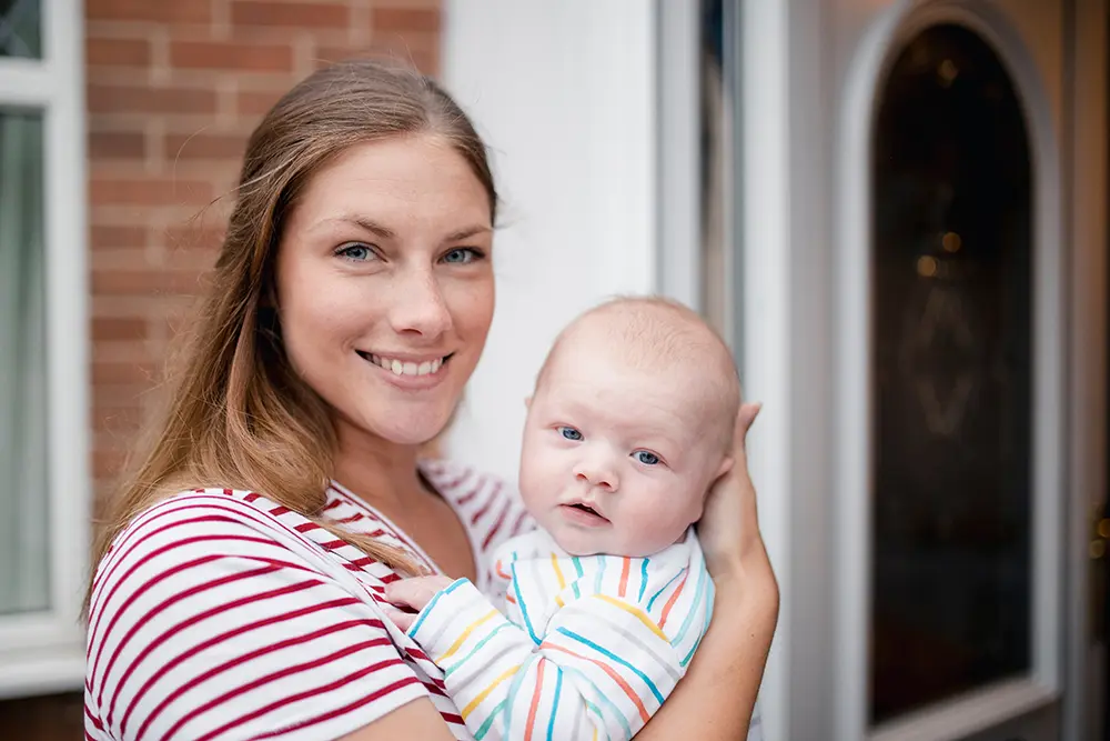 Mother and baby outside their home